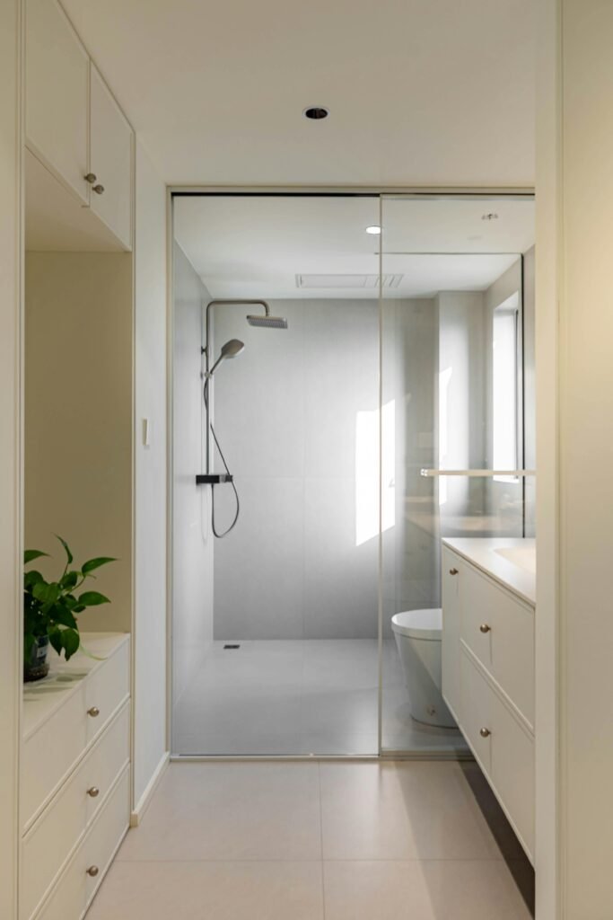 Bright and elegant modern bathroom with glass shower and sleek cabinetry.